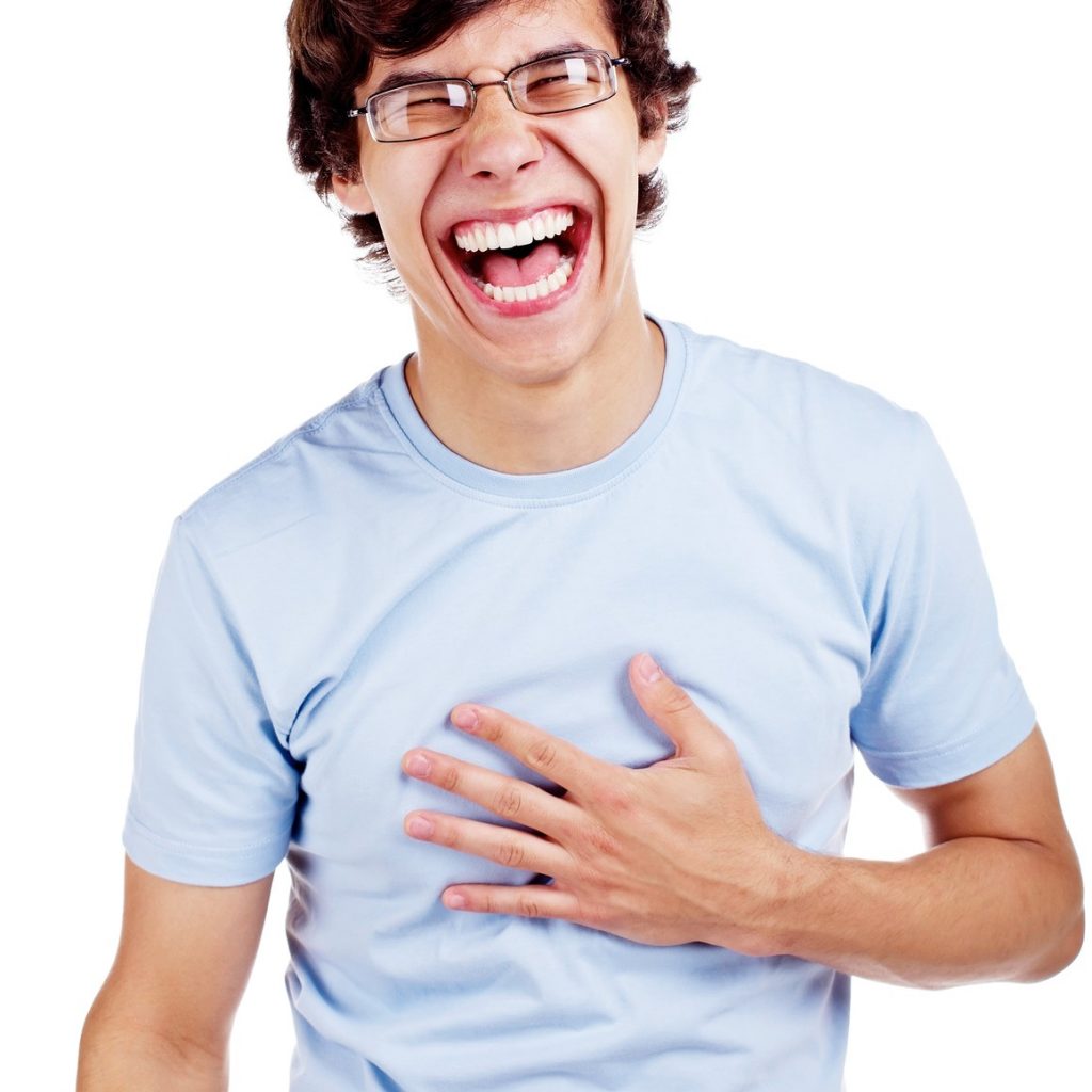 Laughing young man with hand on his chest. Isolated on white bac ...